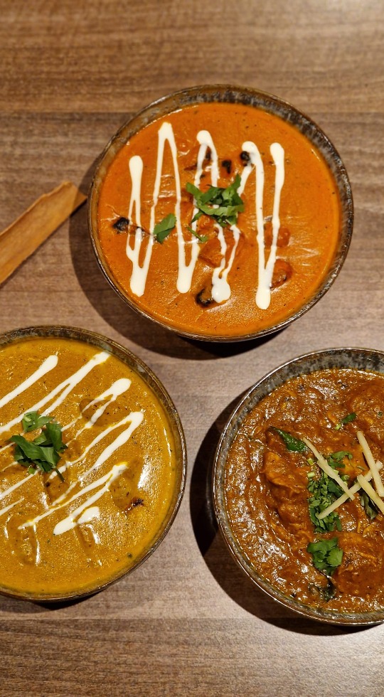 Indian Tapas at its finest, Papa J's Luton Three bowls filled with curry, garnished with cream and coriander
