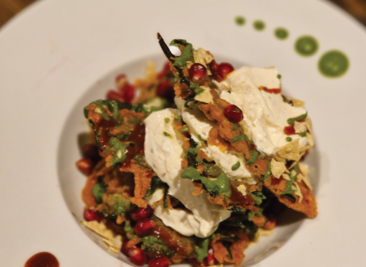 White bowl filled with Indian Tapas garnished with pomegranate seeds